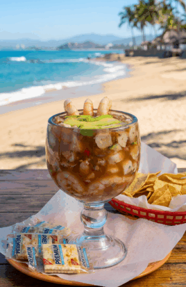 Cup of shrimp coctail on a beach background